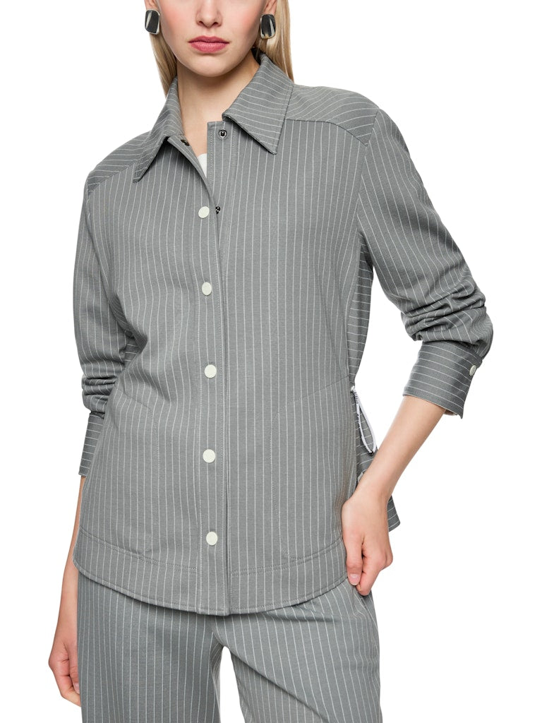 ז'קט בגזרה רחבה ונינוחה, מבד רך וגולש בדוגמת פסי סיכה דקים. גומי במותן מאפשר התאמת רוחב אישית. עם צווארון קלאסי, כיסים חזיתיים, שרוולים ארוכים בסיומת חפתים, וסגירת תיקתקים לכל אורך הז'קט.הרכב: 60% ויסקוזה, 36% פוליאמיד, 4% אלסטןהדוגמנית בגובה 1.79 ולובשת מידה 3 של מארק קיין