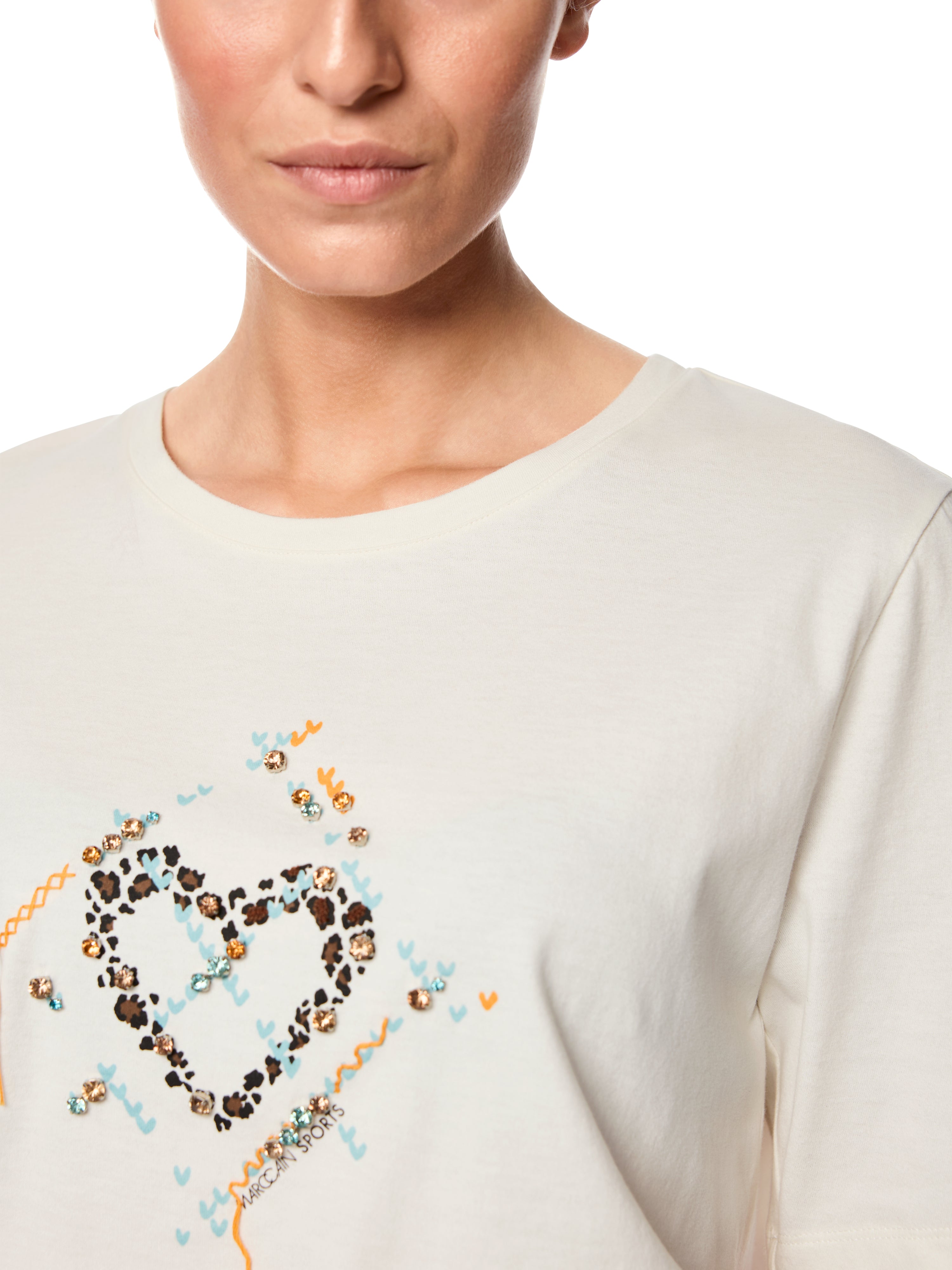 חולצת טישירט נעימה בגזרה ישרה, עם שיבוץ אבנים עיטור ולב בחזית הרכב הבד: 100% כותנההדוגמנית בגובה 1.79 ולובשת מידה 3 של מארק קיין