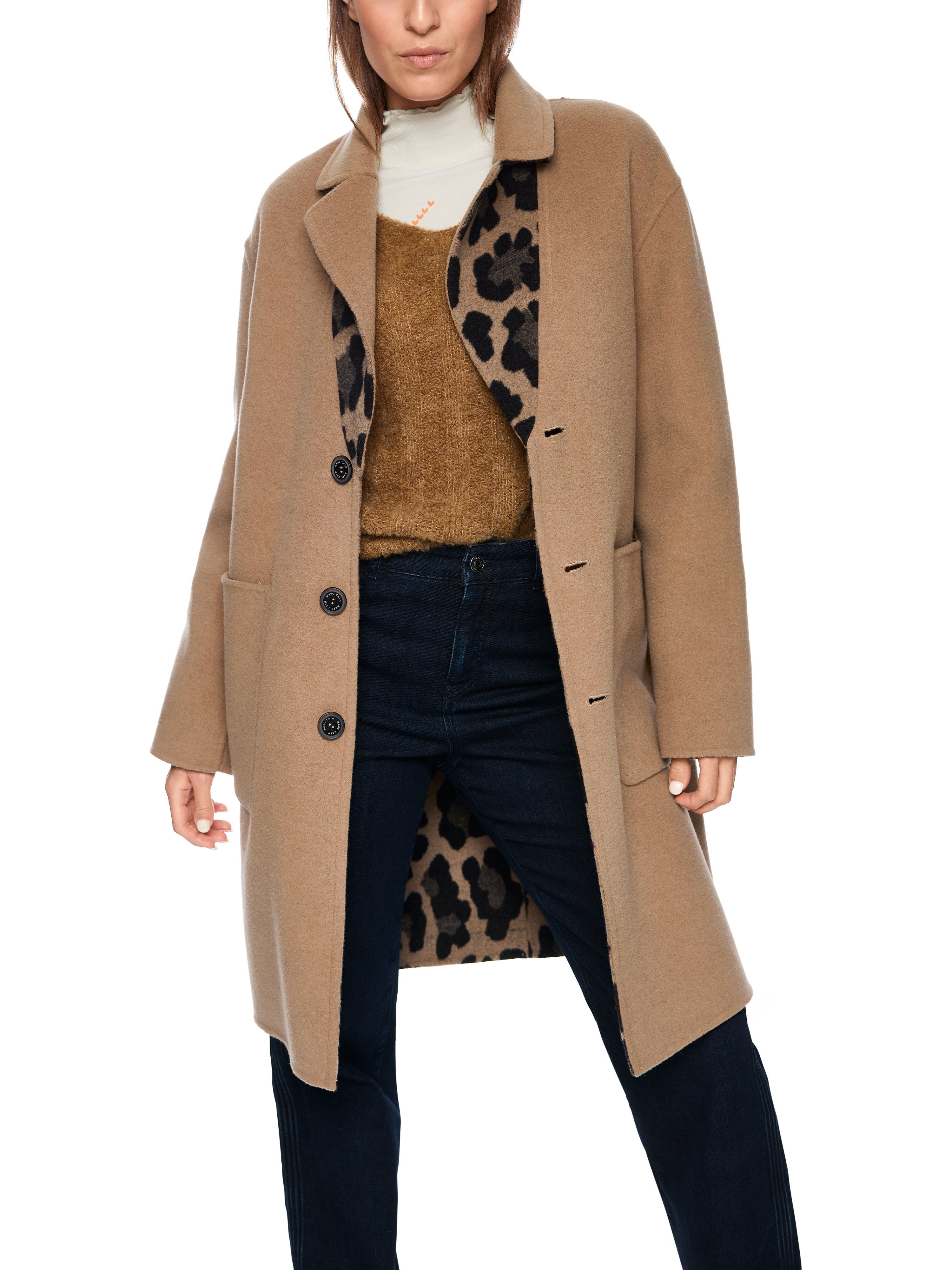 מעיל דו צדדי בגזרה ישרה, צד אחד בדוגמת נמר עם כיסי רוכסן, הצד השני בגוון בז' אלגנטי עם כיסים פתוחיםאורך המעיל מסתיים מעל הברך ונסגר בשלושה כפתוריםהרכב בד: 80% צמר, 20% פוליאמידהדוגמנית בגובה 1.79 ולובשת מידה 3 של מארק קיין 