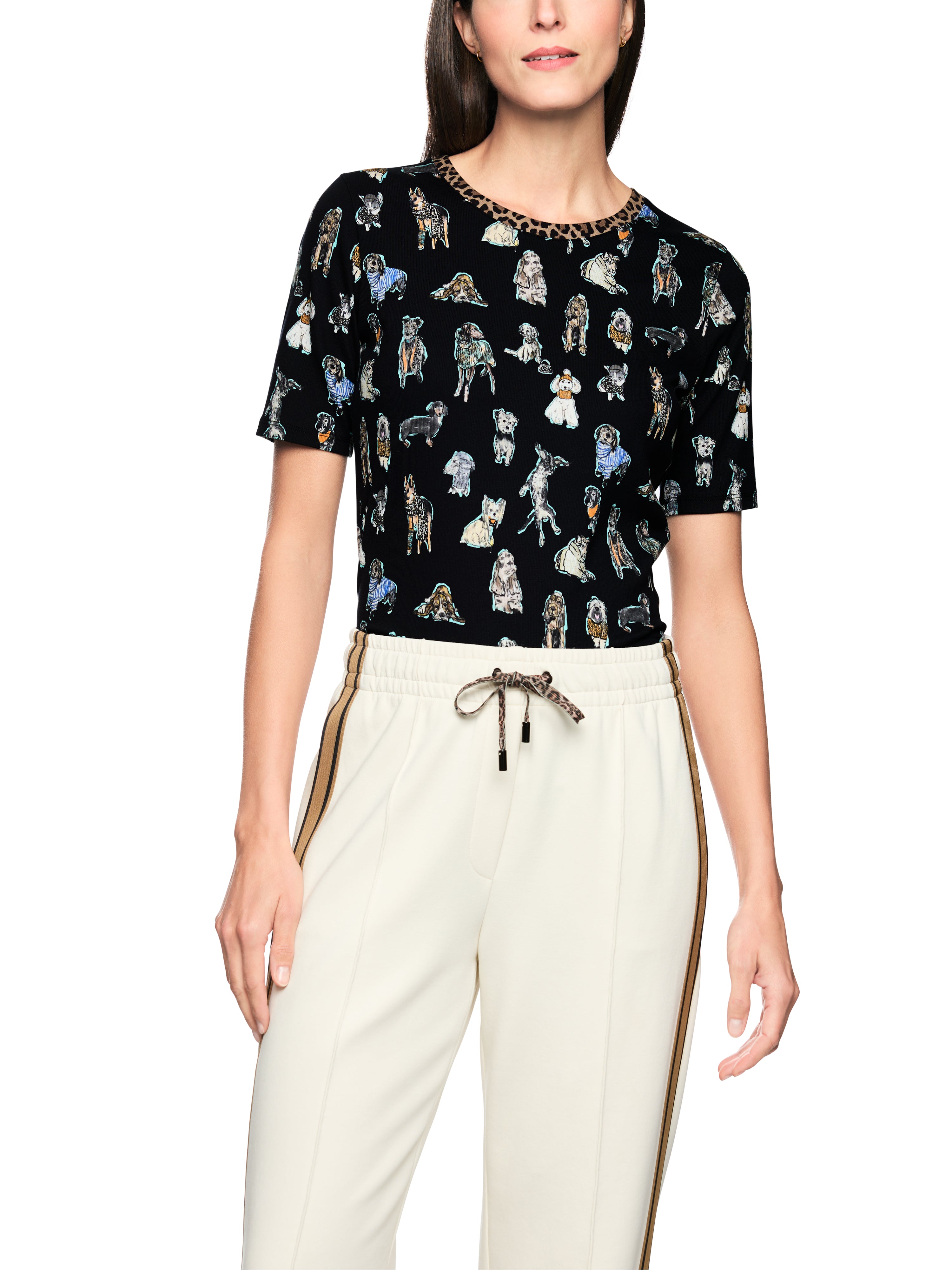 חולצה שחורה רכה עם הדפס כלבים צבעוני בעלת גזרה ישרה וצווארון עגול עם פס מנומר עדין בקצההרכב בד: 96% כותנה, 4% אלסטןהדוגמנית בגובה 1.79 ולובשת מידה 3 של מארק קיין