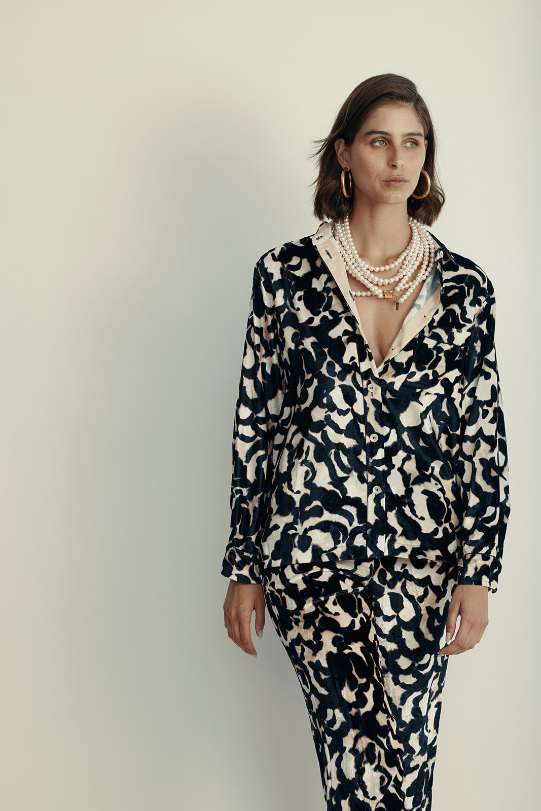 חולצה מכופתרת מבד קטיפה עם הדפס ורדים הרכב: 75% ויסקוזה, 25% פוליאסטר; בד משני: 60% אצטט, 40% ויסקוזההדוגמנית בגובה 1.80 ולובשת מידה 40 איטלקית (מידה I של פורטה פורטה)