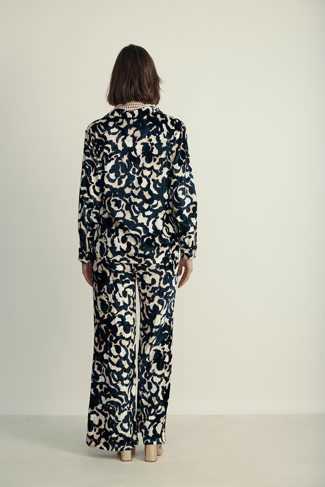 מכנסי קטיפה מתרחבים עם רצועת מותן בהדפס ורדיםהרכב: 75% ויסקוזה, 25% פוליאסטר; בד משני: 60% אצטט, 40% ויסקוזההדוגמנית בגובה 1.80 ולובשת מידה 40 איטלקית (מידה I של פורטה פורטה)