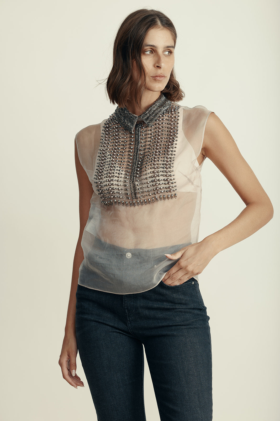 חולצת משי שקופה ללא שרוולים, מעוטרת בניטים וחרוזים בחלק הקידמיהרכב: 100% משיהדוגמנית בגובה 1.80 ולובשת מידה 42 איטלקית