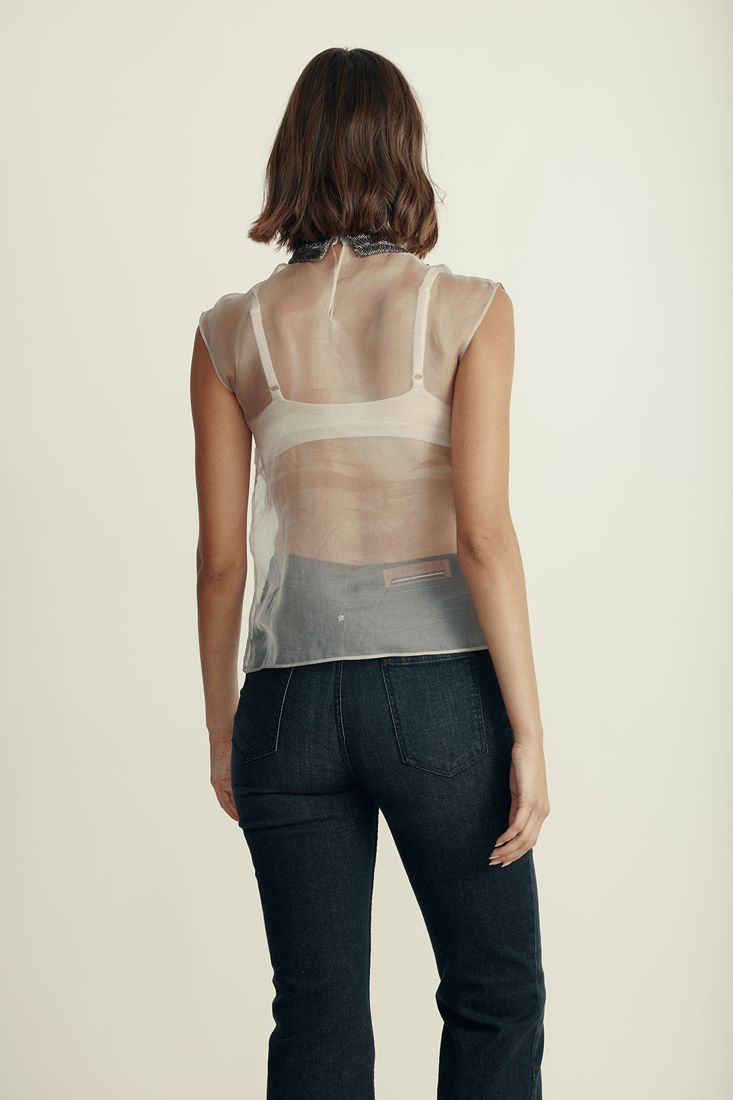 חולצת משי שקופה ללא שרוולים, מעוטרת בניטים וחרוזים בחלק הקידמיהרכב: 100% משיהדוגמנית בגובה 1.80 ולובשת מידה 42 איטלקית