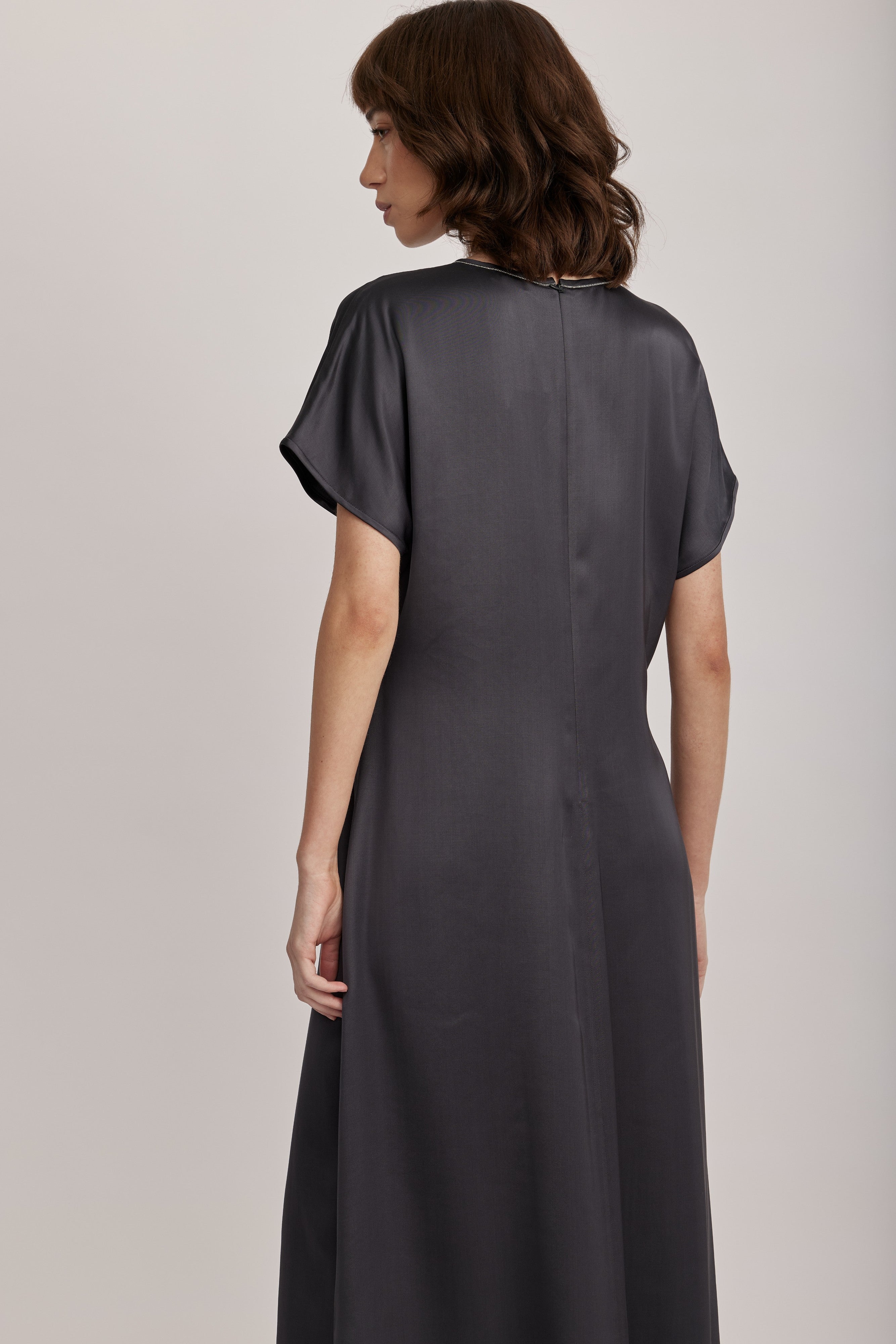 שמלה מבית המותג האיטלקי PESERICO, מבד סאטן רך וזורם, בעל ברק אלגנטי. השמלה בגזרה משוחררת וצללית A עדינה, צווארון עגול מעוטר בדיטייל שרשרת כסופה, שרוולי קימונו קצרים, וסגירה באמצעות רוכסן אחורי נסתר.הרכב: 100% ויסקוזההדוגמנית בגובה 1.75 ולובשת מידה 42 של PESERICO