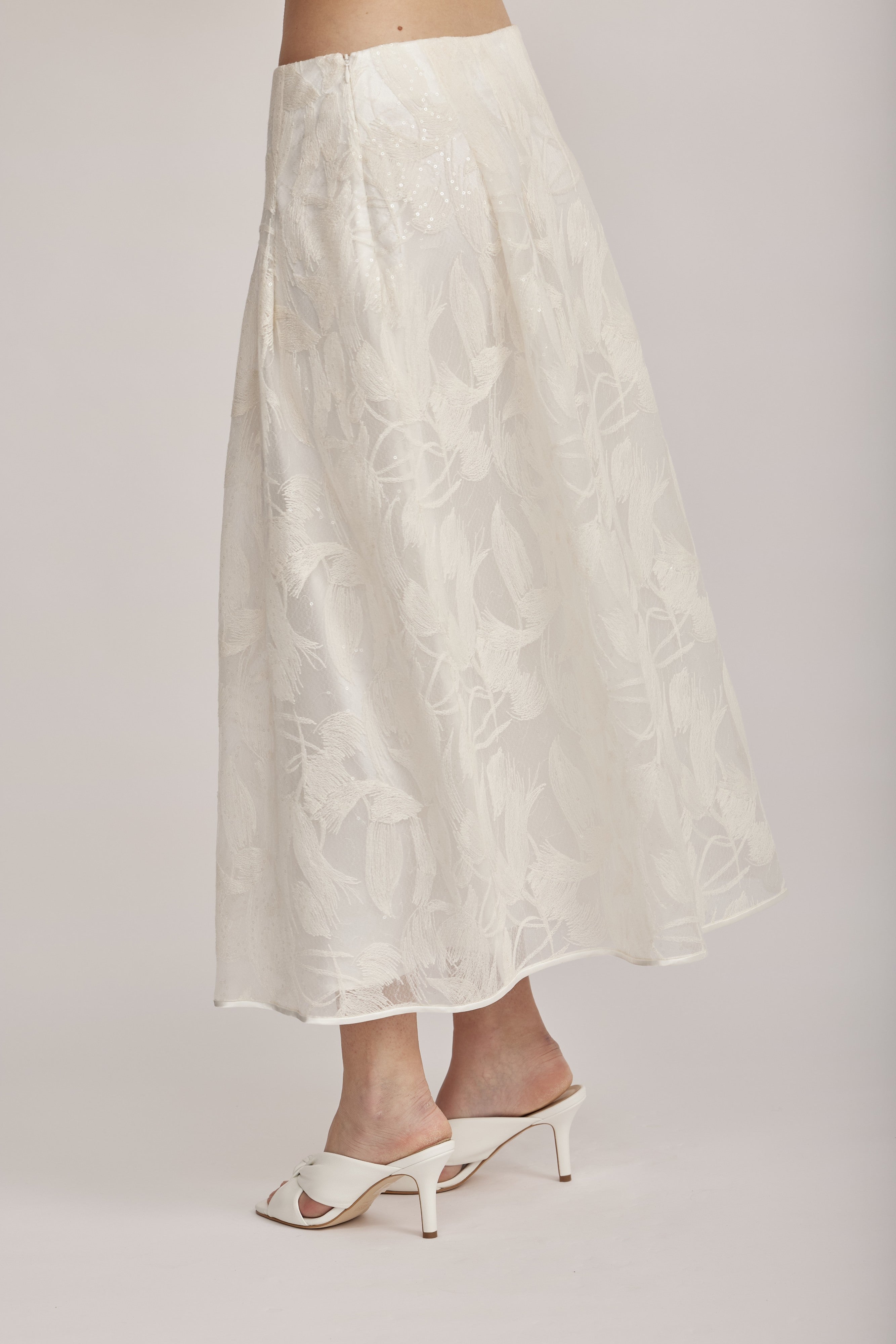 חצאית מקולקציית ה-Runway של המותג האיטלקי PESERICO, בעיצוב דו-שכבתי המשלב בד טול שקוף מעוטר ברקמה עדינה עם פאייטים בדוגמת עלים, ובד אורגנזה דק וקליל בגוון תואם, היוצר משחקי טקסטורה ושקיפויות, ומראה ייחודי.החצאית באורך מידי, בגזרה מתרחבת ונינוחה, עם קפלים מודגשים, בטנה פנימית, וסגירה באמצעות רוכסן צידי נסתר.הרכב: טול- 50% פוליאמיד, 50% כותנה, אורגנזה- 100% פוליאסטר, בטנה- 97% פוליאסטר, 3% אלסטןהדוגמנית בגובה 1.75 ולובשת מידה 42 של PESERICO