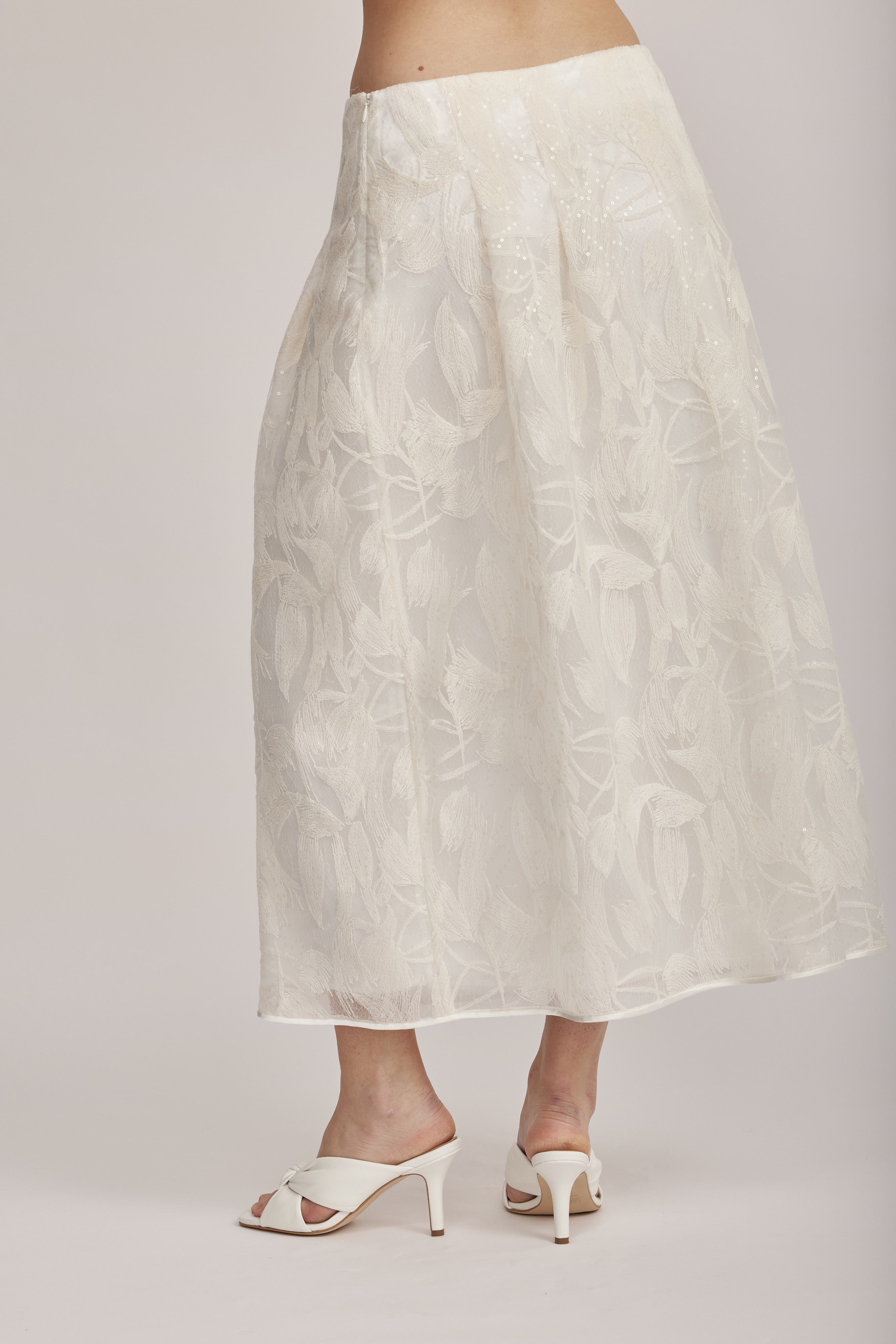 חצאית מקולקציית ה-Runway של המותג האיטלקי PESERICO, בעיצוב דו-שכבתי המשלב בד טול שקוף מעוטר ברקמה עדינה עם פאייטים בדוגמת עלים, ובד אורגנזה דק וקליל בגוון תואם, היוצר משחקי טקסטורה ושקיפויות, ומראה ייחודי.החצאית באורך מידי, בגזרה מתרחבת ונינוחה, עם קפלים מודגשים, בטנה פנימית, וסגירה באמצעות רוכסן צידי נסתר.הרכב: טול- 50% פוליאמיד, 50% כותנה, אורגנזה- 100% פוליאסטר, בטנה- 97% פוליאסטר, 3% אלסטןהדוגמנית בגובה 1.75 ולובשת מידה 42 של PESERICO