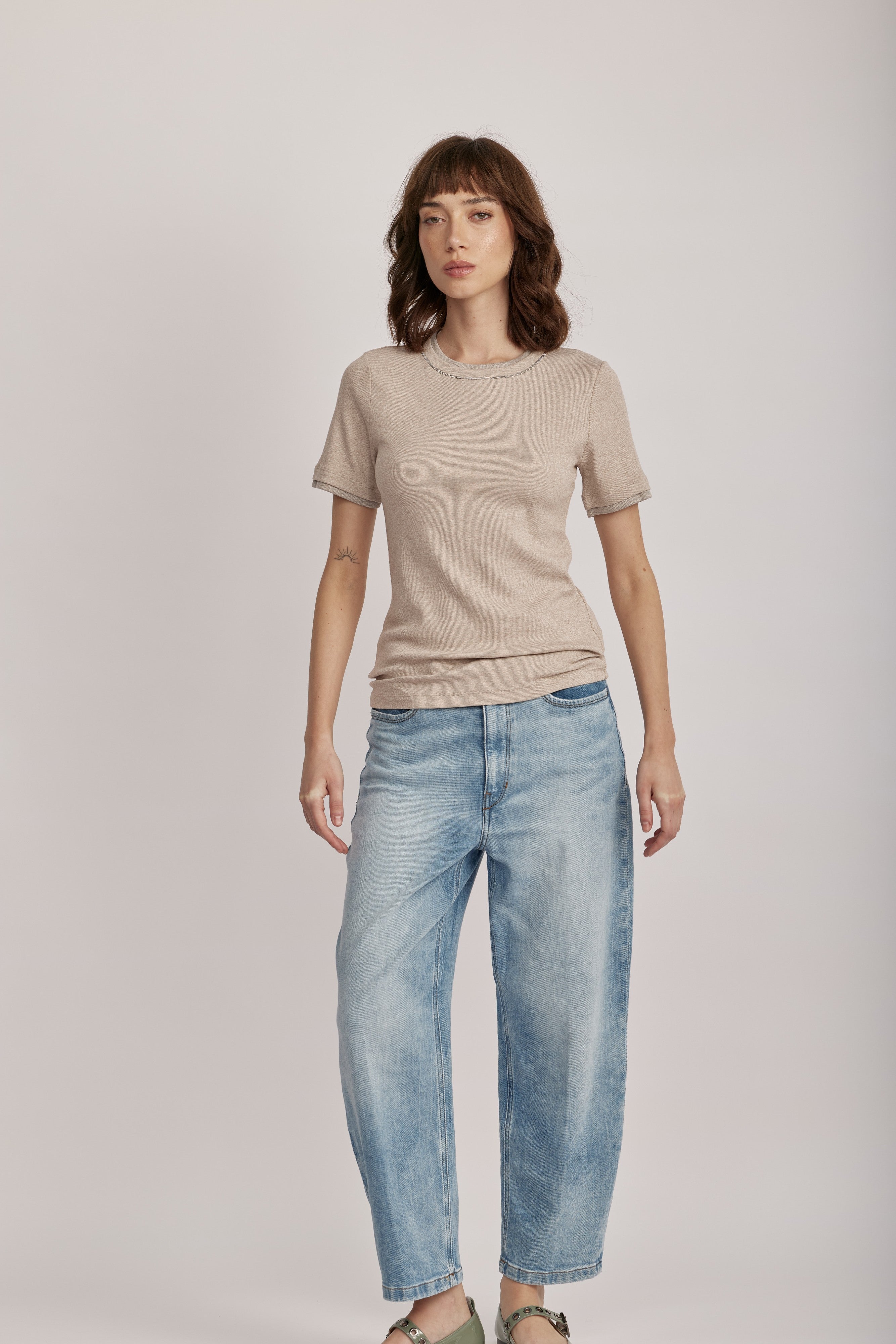 טישירט מבית המותג האיטלקי PESERICO, מכותנה ג'רזי אלסטית בטקסטורת פסי ריב דקיקים. גזרה צמודה, עם צווארון עגול ושרוולים קצרים, ותוספת מכפלת בשרוולים ובצווארון, בשילוב לורקס בגימור מטאלי להדגשת העיצוב.הרכב: 94% כותנה, 6% אלסטןהדוגמנית בגובה 1.75 ולובשת מידה 42 של PESERICO