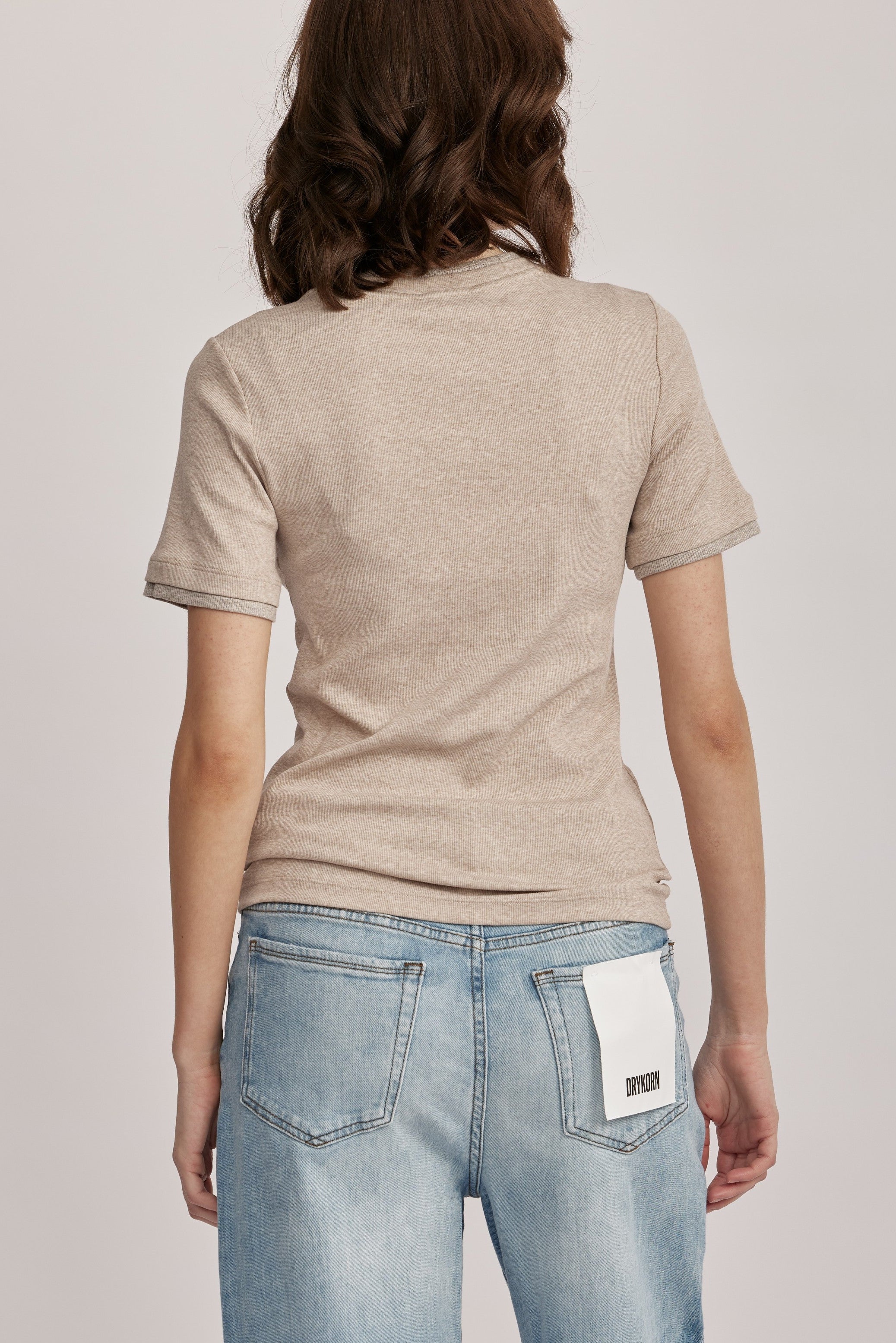 טישירט מבית המותג האיטלקי PESERICO, מכותנה ג'רזי אלסטית בטקסטורת פסי ריב דקיקים. גזרה צמודה, עם צווארון עגול ושרוולים קצרים, ותוספת מכפלת בשרוולים ובצווארון, בשילוב לורקס בגימור מטאלי להדגשת העיצוב.הרכב: 94% כותנה, 6% אלסטןהדוגמנית בגובה 1.75 ולובשת מידה 42 של PESERICO