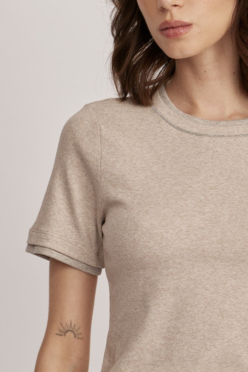 טישירט מבית המותג האיטלקי PESERICO, מכותנה ג'רזי אלסטית בטקסטורת פסי ריב דקיקים. גזרה צמודה, עם צווארון עגול ושרוולים קצרים, ותוספת מכפלת בשרוולים ובצווארון, בשילוב לורקס בגימור מטאלי להדגשת העיצוב.הרכב: 94% כותנה, 6% אלסטןהדוגמנית בגובה 1.75 ולובשת מידה 42 של PESERICO