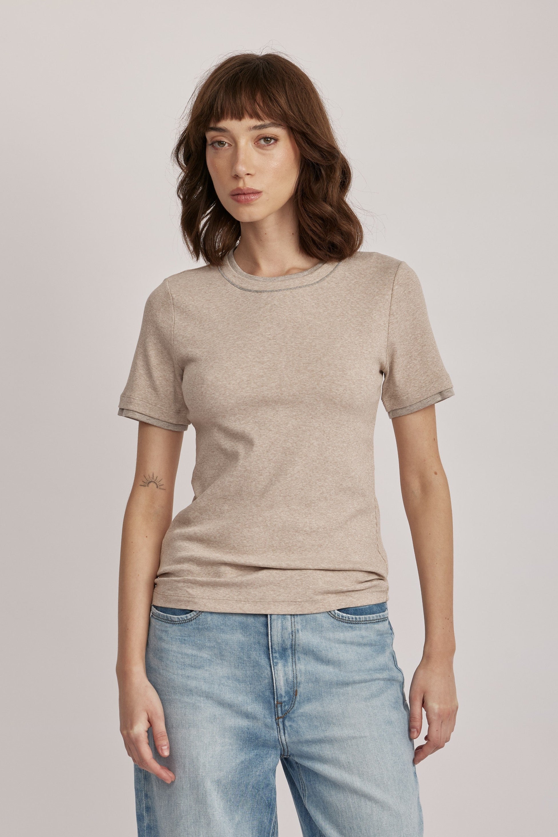 טישירט מבית המותג האיטלקי PESERICO, מכותנה ג'רזי אלסטית בטקסטורת פסי ריב דקיקים. גזרה צמודה, עם צווארון עגול ושרוולים קצרים, ותוספת מכפלת בשרוולים ובצווארון, בשילוב לורקס בגימור מטאלי להדגשת העיצוב.הרכב: 94% כותנה, 6% אלסטןהדוגמנית בגובה 1.75 ולובשת מידה 42 של PESERICO