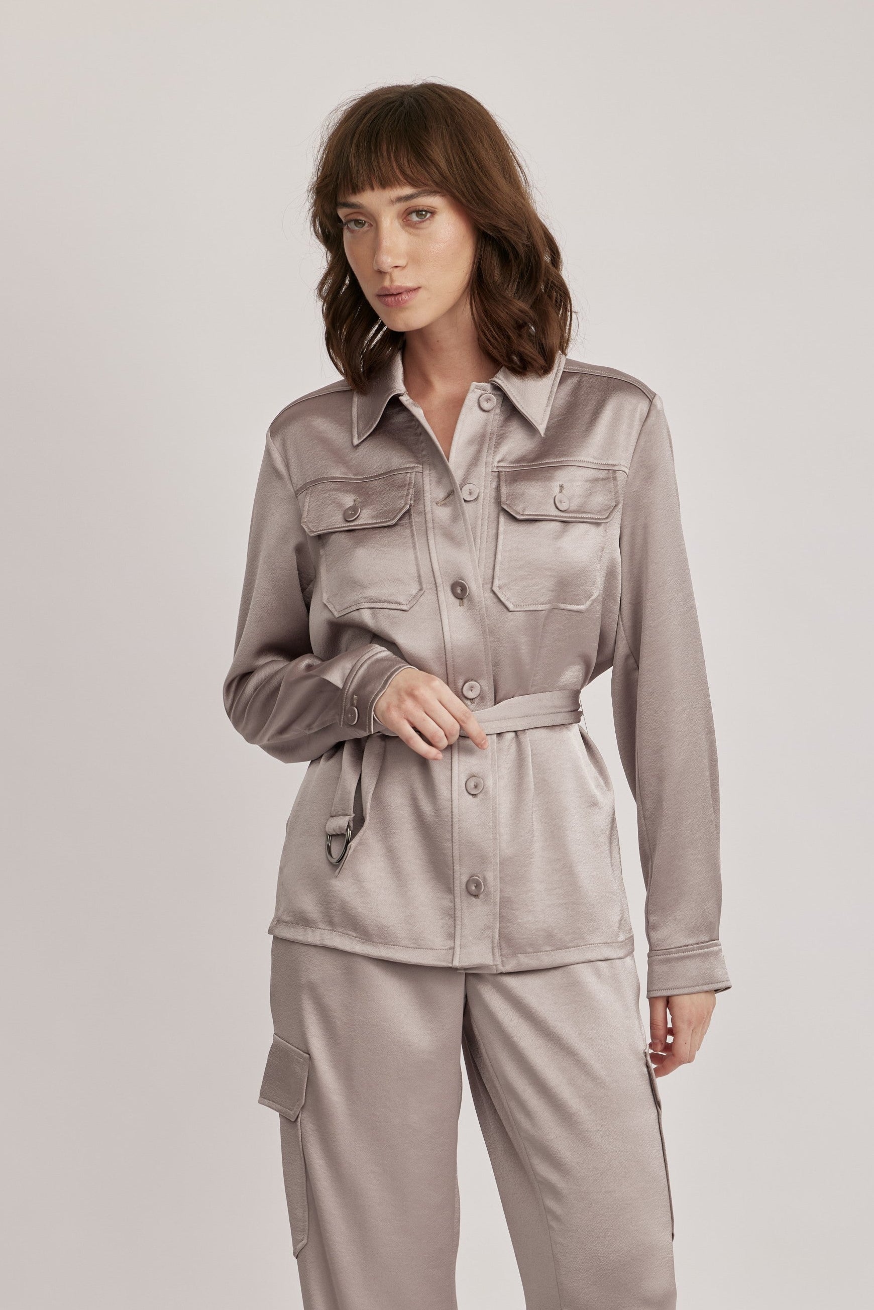 חולצה מבית המותג RIANI בעיצוב מודרני ואלגנטי, מבד סאטן רך וגולש בעל ברק מטאלי עדין, עם חגורת מותן נשלפת, להתאמה אישית ומגוון אפשרויות לבישה. גזרה ישרה, עם צווארון קלאסי, שני כיסי חזה מכופתרים, שרוולים ארוכים בגימור חפתים, וסגירת כפתורים לכל האורך.הרכב: 100% פוליאסטרהדוגמנית בגובה 1.75 ולובשת מידה 36 אירופאית