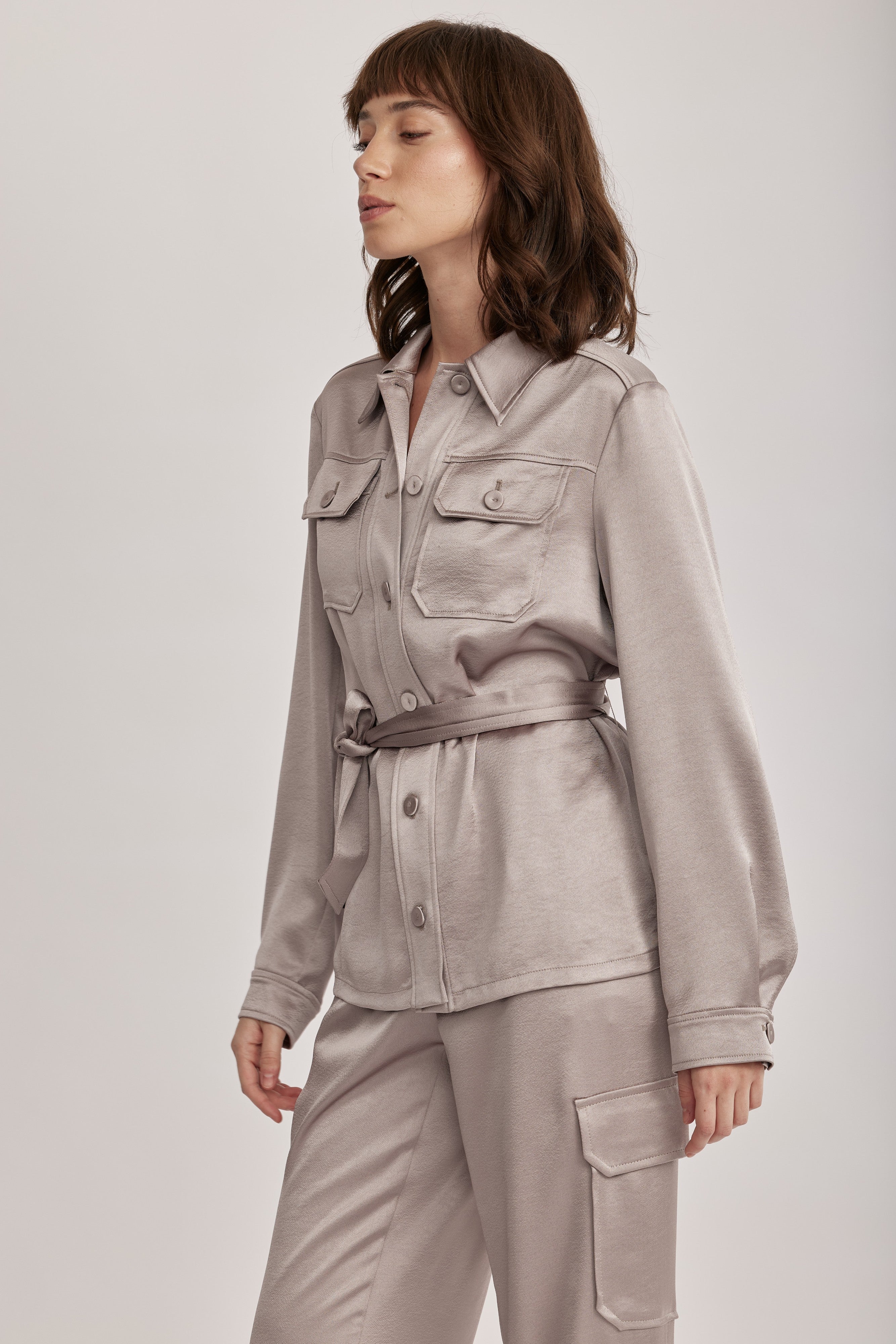 חולצה מבית המותג RIANI בעיצוב מודרני ואלגנטי, מבד סאטן רך וגולש בעל ברק מטאלי עדין, עם חגורת מותן נשלפת, להתאמה אישית ומגוון אפשרויות לבישה. גזרה ישרה, עם צווארון קלאסי, שני כיסי חזה מכופתרים, שרוולים ארוכים בגימור חפתים, וסגירת כפתורים לכל האורך.הרכב: 100% פוליאסטרהדוגמנית בגובה 1.75 ולובשת מידה 36 אירופאית