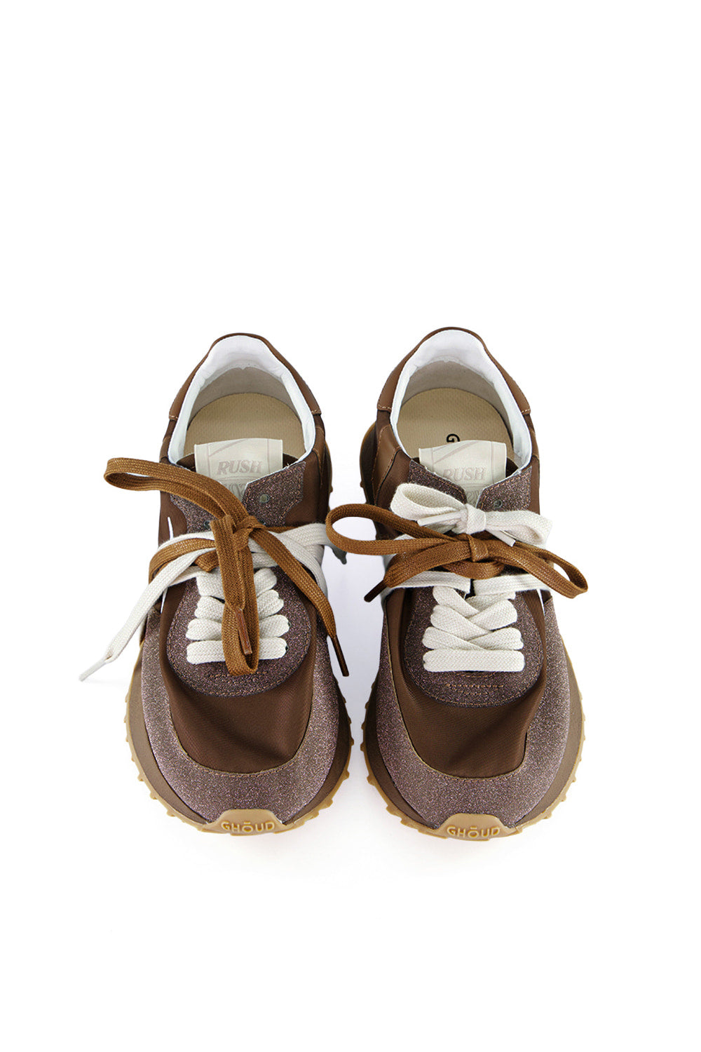 נעלי סניקרס לנשים מבית המותג האיטלקי Ghoud Venice, בעיצוב חדשני המשלב אסתטיקה מינימליסטית עם קווים גיאומטריים וחיתוכים נועזים, למראה עדכני ומתוחכם.הנעליים מיוצרות בעבודת יד, תוך מחשבה והקפדה על הפרטים הקטנים, מה שמבטיח סטייל ונוחות מקסימליים.החלק העליון עשוי בד בגימור מנצנץ, בד ניילון, ועור איכותיים ועמידים, עם שרוכים כפולים. סוליית גומי Phylon מוגבהת, רכה וקלה, מעניקה תמיכה ויציבות. הדפס לוגו המותג בצידי הנעל.הרכב: 95% בד, 5% עור. סוליה: 60% פיילון (Phylon), 40% גומי תרמו עמיד