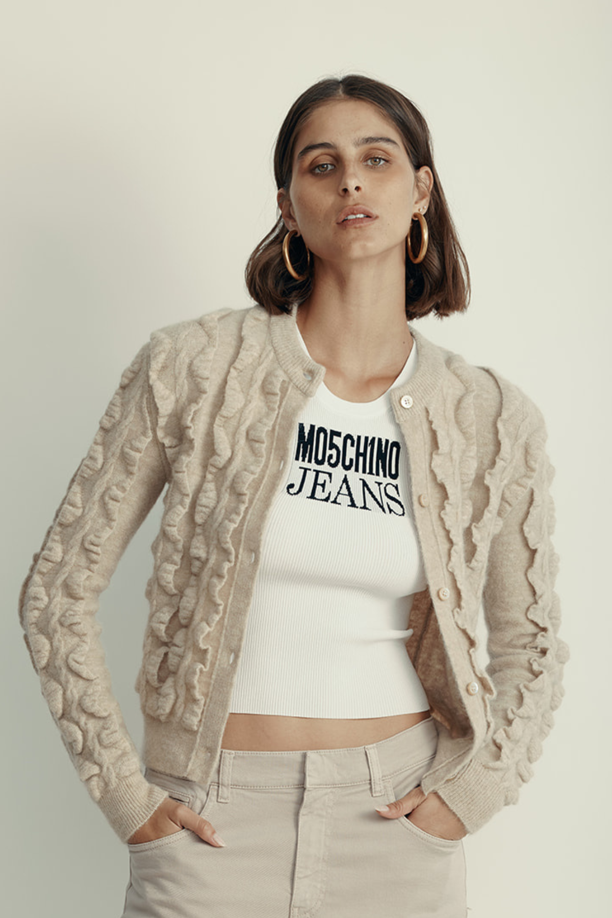 קרדיגן מקולקציית MOSCHINO Couture עם אלמנט מלמלה וסגירת כפתוריםהרכב: 30% צמר וירג'ין, 38% פוליאמיד, 31% מוהיר, 1% אלסטןהדוגמנית בגובה 1.80 ולובשת מידה 42 איטלקית 