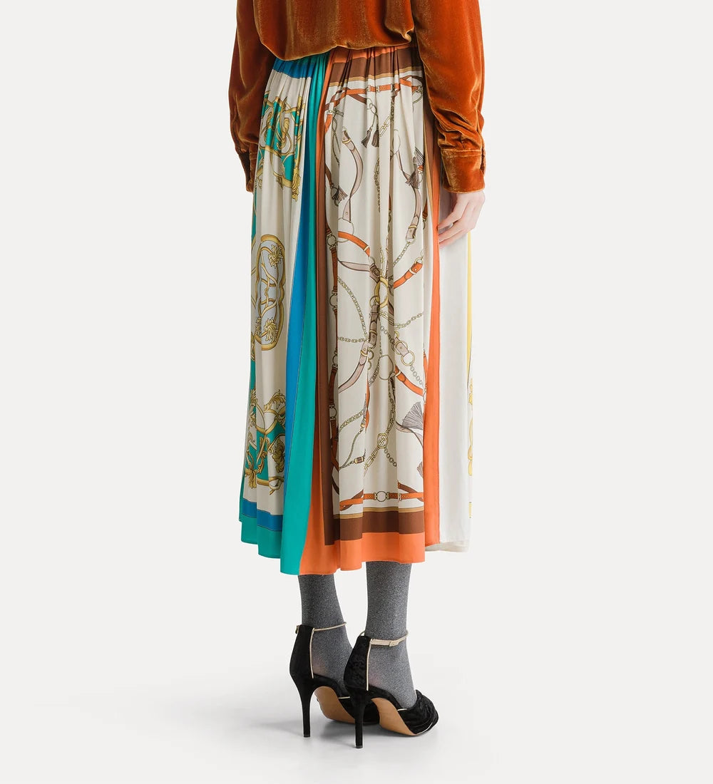 הקודים של המלתחה המלכותית מפורקים ומורכבים מחדש בחצאית מויסקוזה עם מגע משיי, בעיצוב קליל עם אפקט קפלים וסיומת מתרחבת. החצאית בגזרה אוברסייז מעוטרת בהדפס ממוקם בהשראת הגרפיקה האיקונית של צעיפים אנגליים, עם פרטים מעולם מוצרי העור: רצועות, שרשראות, סרטים צבעוניים וגדילים. בזכות המותן האלסטית וההדפס הרב־גוני, אפשר ללבוש את החצאית בחופשיות, בלי לדאוג לכיוון.הרכב הבד:100% ויסקוזהבד משני: 100% כותנה