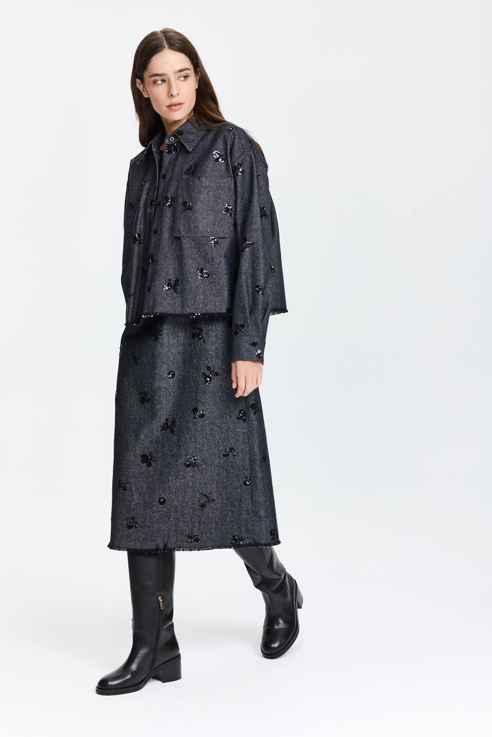 שמלת ג'ינס אלגנטית בגזרה מתרחבת, בצבע כחול כהה עם פאייטים עדינים בחזיתלשמלה חולצה תואמתהרכב: 57% ויסקוזה, 43% פוליאסטרהדוגמנית בגובה 1.75 ולובשת מידה 36 של Luisa Cerano