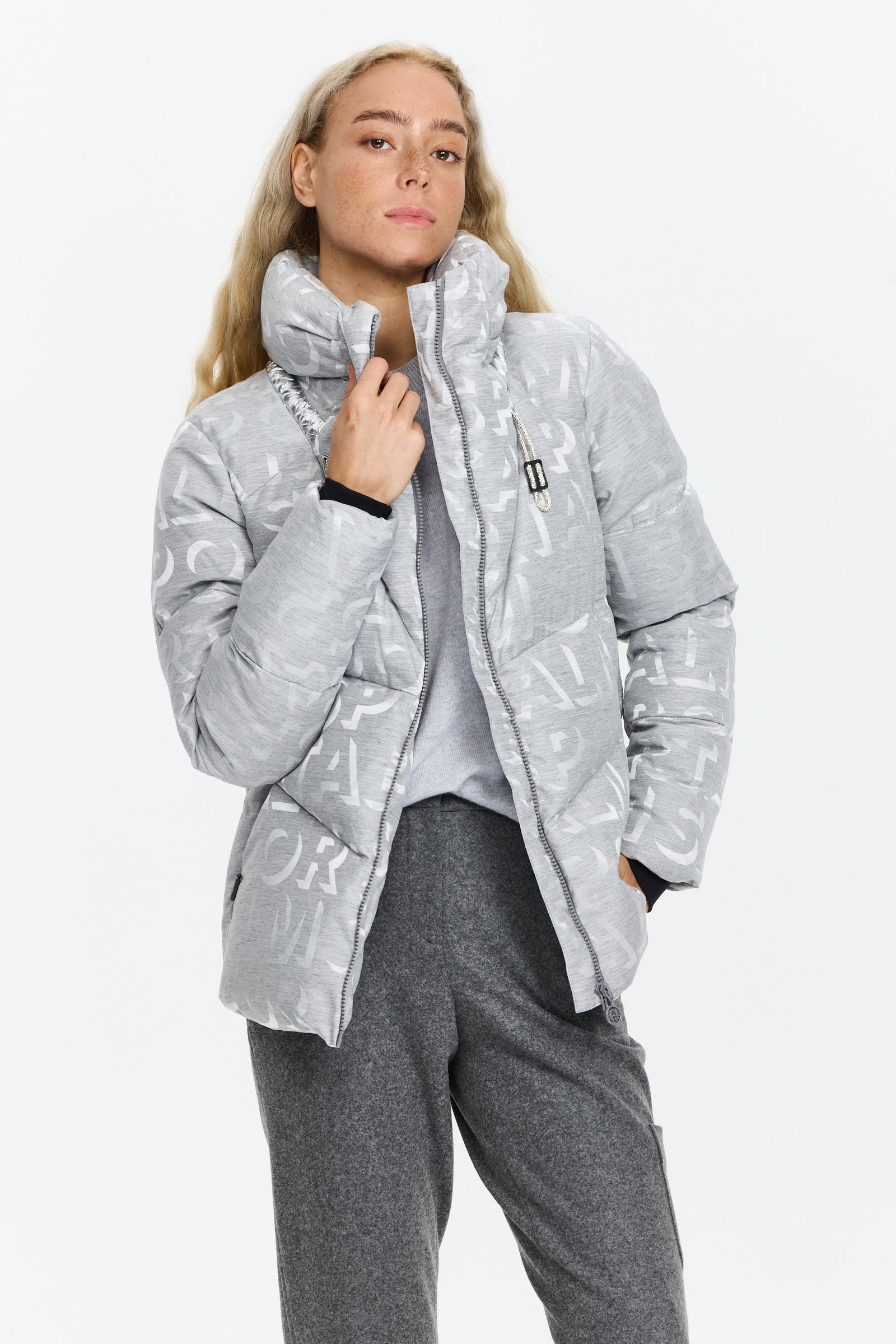 מעיל נוצות בעיצוב ג’קארד עם צווארון גבוה מרופד, סגירת רוכסן כפולה וכיסים צדדייםהרכב בד: בד ג’קארד משולב ניילון, מילוי נוצותהדוגמנית בגובה 1.75 ולובשת מידה 36 של Sportalm