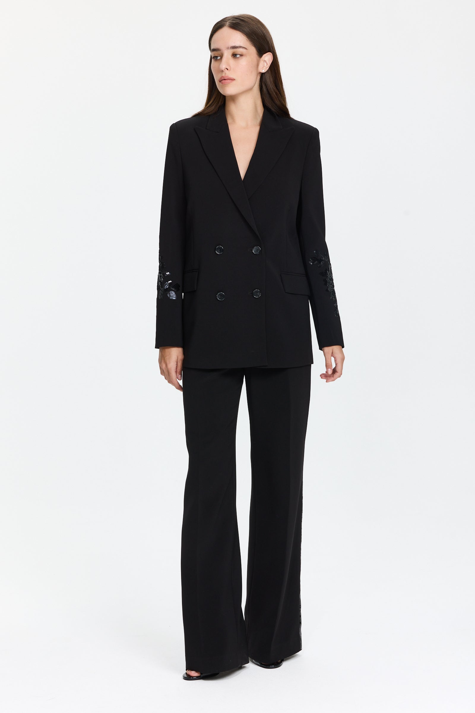 ז’קט בלייזר בצבע שחור עם פאייטים בשרווליםכולל כיסים צדדיים ומראה אלגנטיהרכב בד: 94% פוליאסטר, 6% אלסטןהדוגמנית בגובה 1.75 ולובשת מידה 42 של Ermanno Scervino