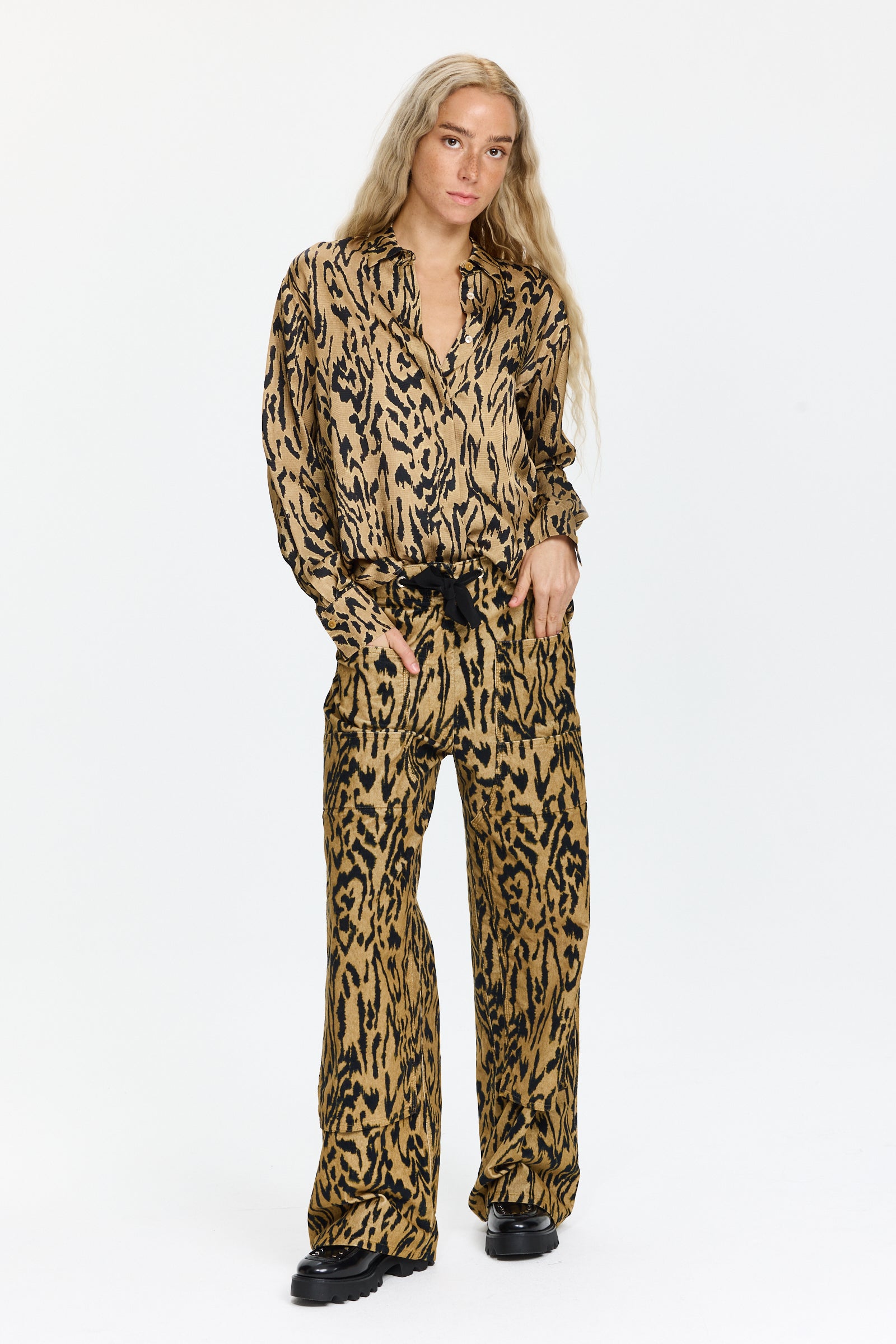 מכנסי קרגו מקטיפה עם הדפס שחור וטקסטורה עדינה.בעלי גזרה רחבה, כיסים צדיים, מותן עם גומי ושרוך קשירההרכב: 97% כותנה, 3% אלסטןהדוגמנית בגובה 1.75 ולובשת מידה 0 של Forte Forte