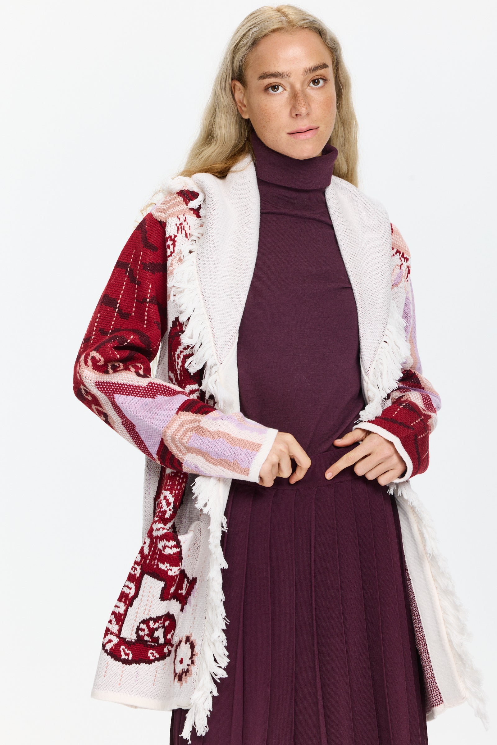 קרדיגן ארוך בסריג ג’קארד, עם כיסים קדמיים, חגורה תואמת, ופרנזים בקצה הרכב בד: 100% צמר מרינוהדוגמנית בגובה 1.75 ולובשת מידה M של Hayley Menzies