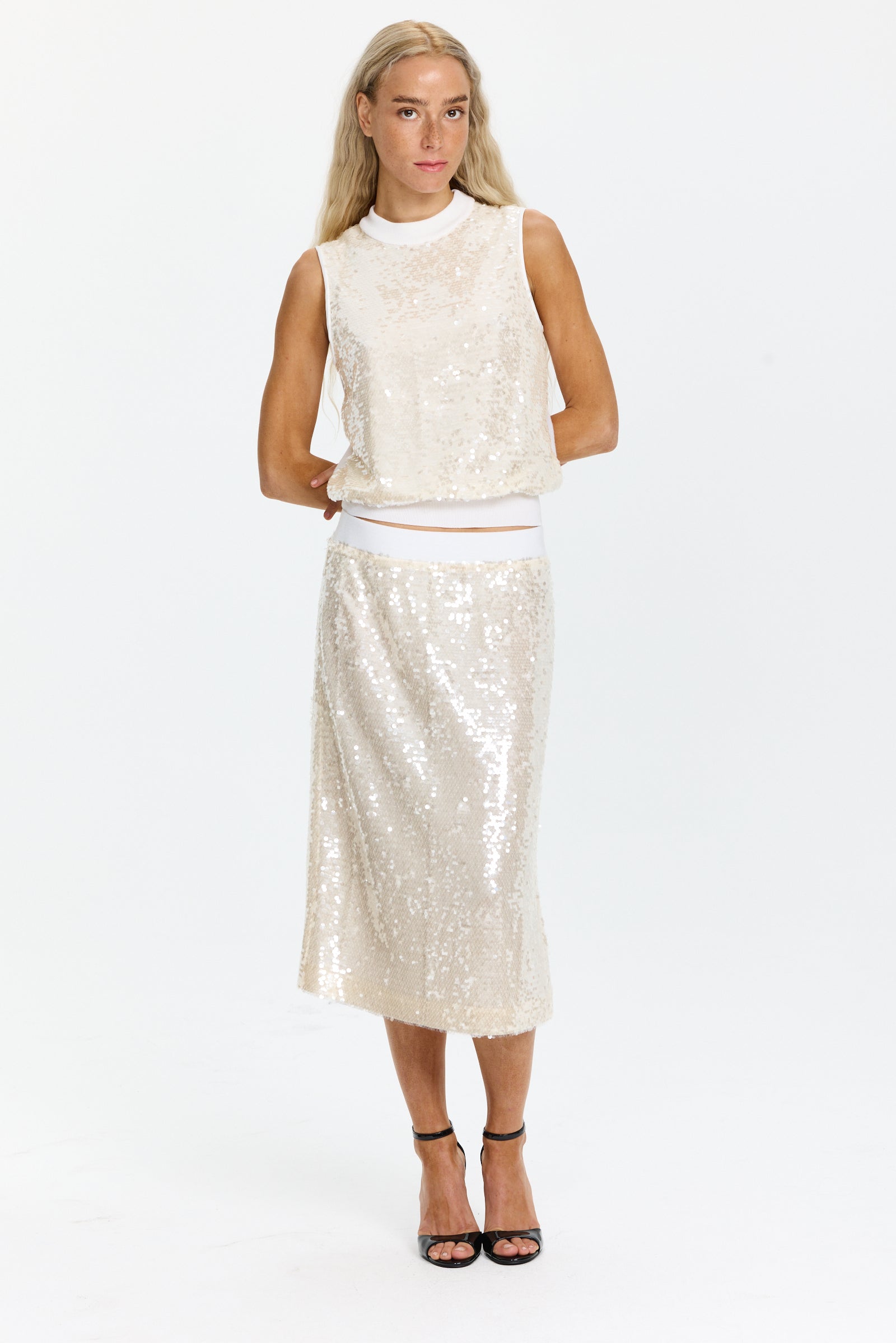 סריג פייאטים חגיגי ללא שרוולים ובגזרה ישרההרכב הבד: 93% פוליאסטר, 7% אלסטןהדוגמנית בגובה 1.75 ולובשת מידה 42 של Peserico