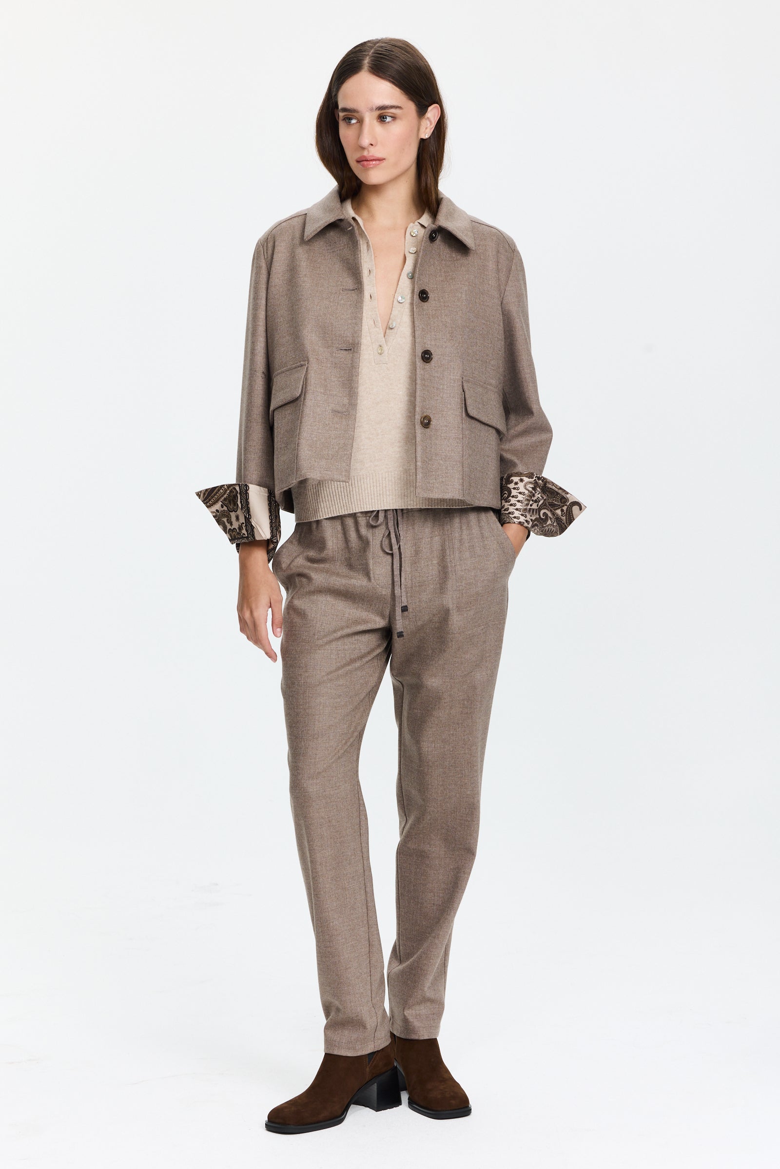 מכנסיים בגזרה ישרה בגוון חום אפרפר עם מותן מתכוונן וחגורת שרוךהרכב בד: 98% צמר, 2% אלסטןהדוגמנית בגובה 1.75 ולובשת מידה 42 של Lorena Antoniazzi