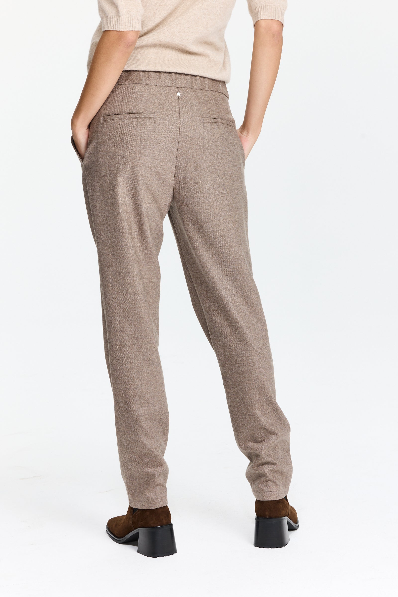 מכנסיים בגזרה ישרה בגוון חום אפרפר עם מותן מתכוונן וחגורת שרוךהרכב בד: 98% צמר, 2% אלסטןהדוגמנית בגובה 1.75 ולובשת מידה 42 של Lorena Antoniazzi