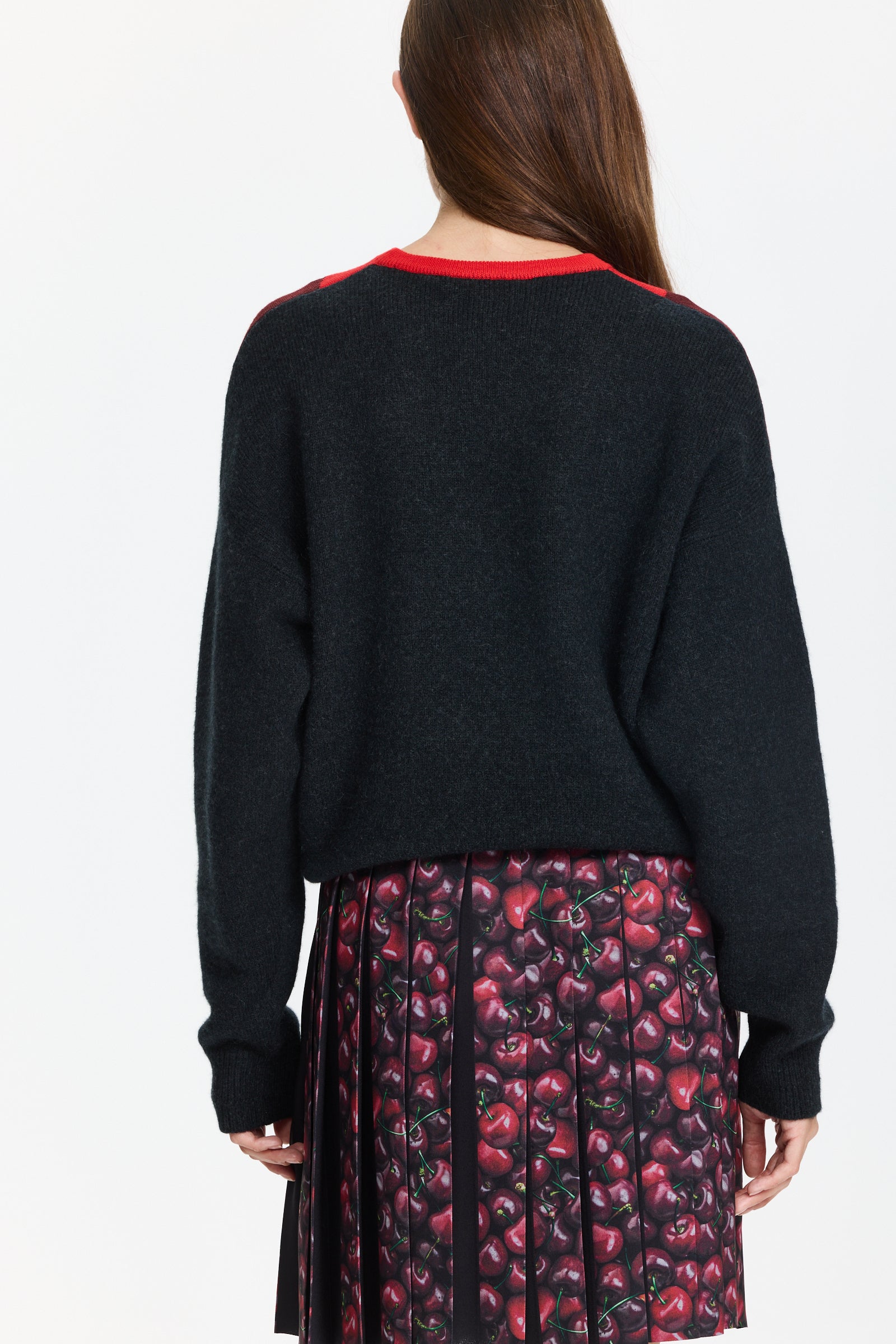 סוודר סרוג עם דוגמת צווארון אדומה ובסיס שחורהרכב הבד: 50% צמר מרינו דק, 30% צמר גמל, 10% ניילון, 10% צמר בתוליהדוגמנית בגובה 1.75 ולובשת מידה 44 של Plan C