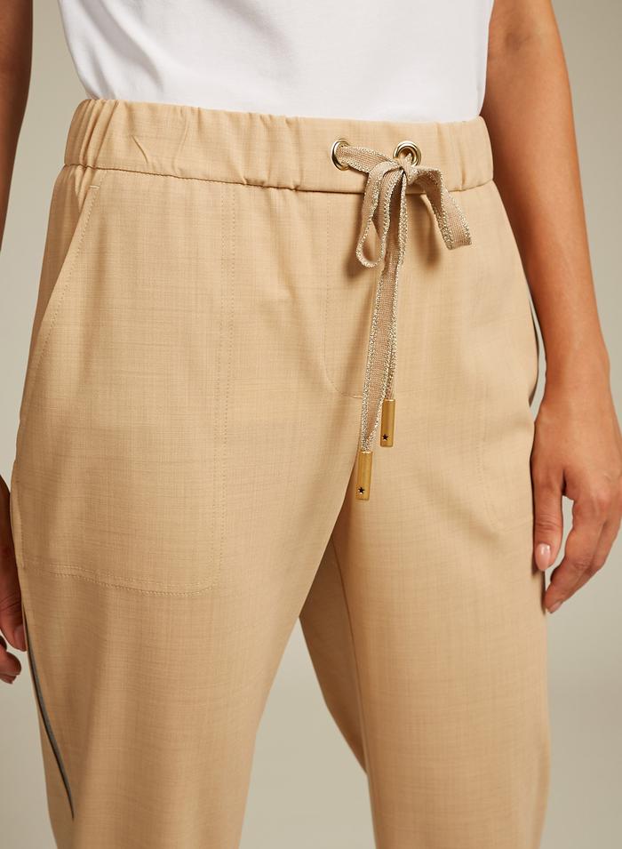 מכנסי צמר בסגנון ספורטיבי עם גומי במותןהרכב: 96% צמר, 4% אלסטןהדוגמנית בגובה 1.75 ולובשת מידה 42 איטלקית