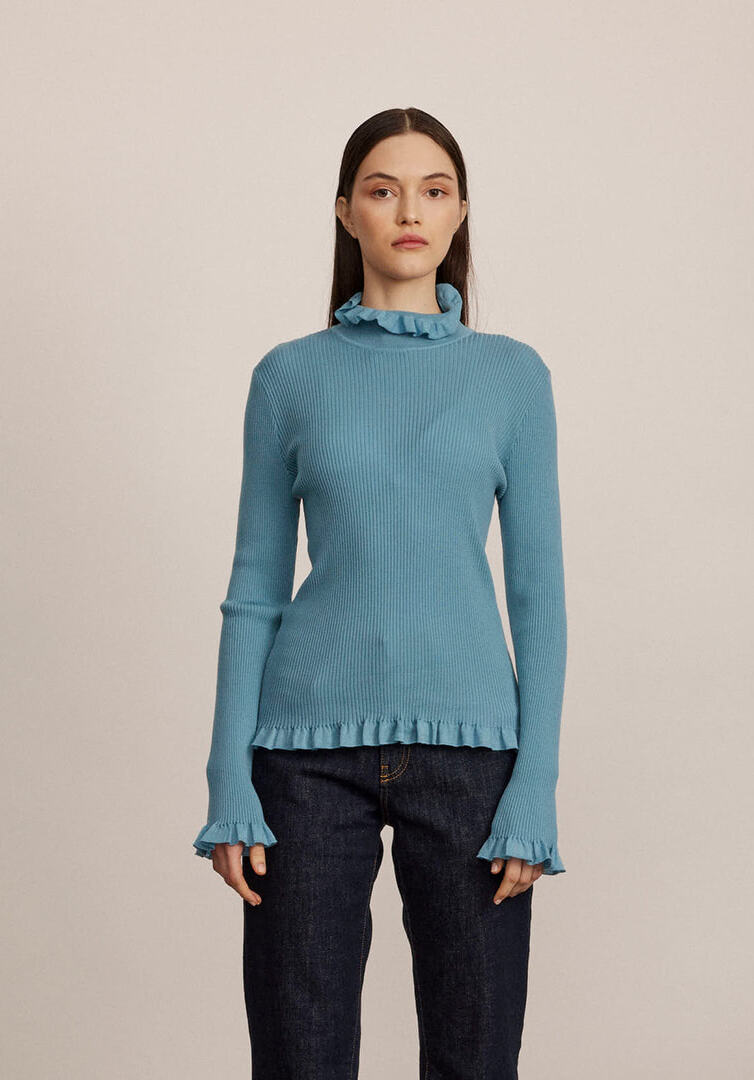 סריג גולף מקולקציית Boutique MOSCHINO עם גימורי ראפלס בסיומת הרכב: 100% צמר וירג'יןהדוגמנית בגובה 1.74 ולובשת מידה 40 איטלקית