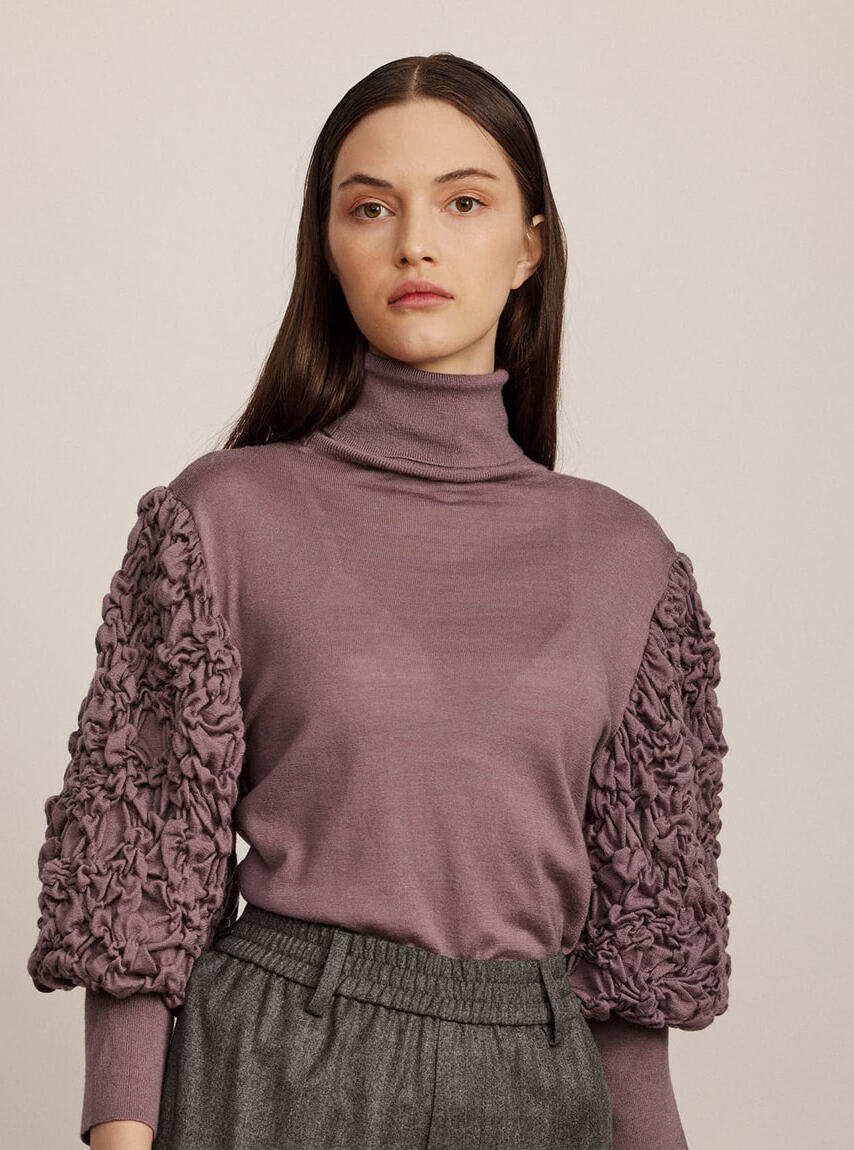 סריג גולף מצמר עם שרוולים נפוחיםהרכב: 70% צמר וירג'ין, 20% משי, 10% קשמירהדוגמנית בגובה 1.74 ולובשת מידה 42 איטלקית