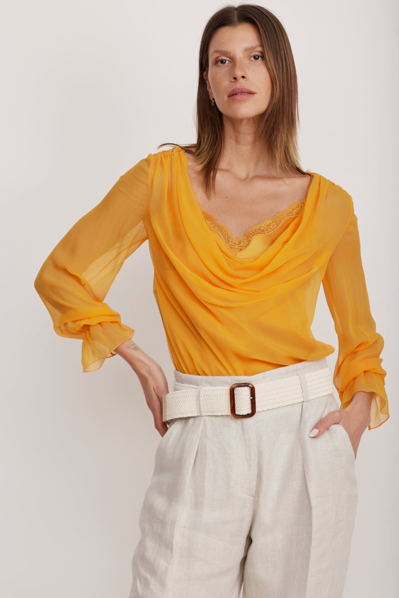 חולצת בלוזון מבד משי עם כיווצים עדינים לאורך קו הצווארון וסיומת תחרה הרכב: 100% משי; בד משני: 100% פוליאמידהדוגמנית בגובה 1.80 ולובשת מידה 40 איטלקית