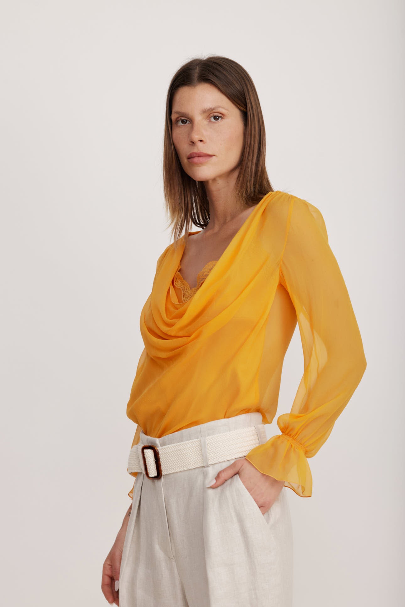 חולצת בלוזון מבד משי עם כיווצים עדינים לאורך קו הצווארון וסיומת תחרה הרכב: 100% משי; בד משני: 100% פוליאמידהדוגמנית בגובה 1.80 ולובשת מידה 40 איטלקית