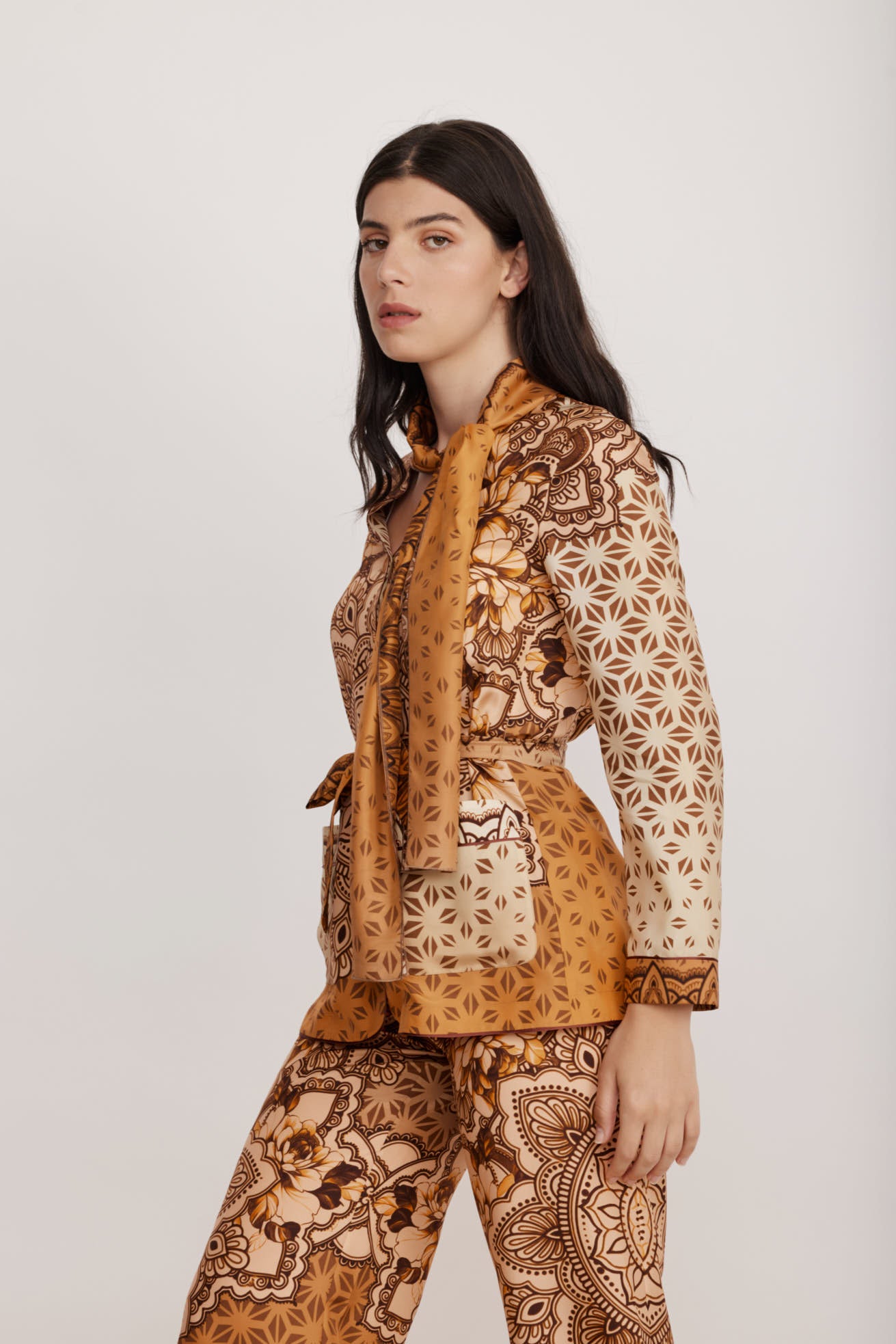 חולצת משי אלגנטית עם כפתורים וצווארון קשירה בהדפס גרפי בתוספת חגורההרכב: 100% משיהדוגמנית בגובה 1.79 לובשת מידה 40 איטלקית