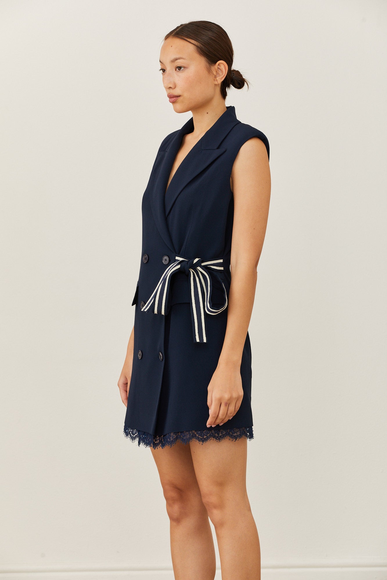 שמלה מחוייטת בסגנון מעטפת בגזרת מיניהרכב: 70% אצטט, 30% ויסקוזה; בטנה: 94% אצטט, 6% ויסקוזה; תחרה: 80% כותנה, 20% פוליאמיד; חגורה צידית: 50% כותנה, 50% ויסקוזההדוגמנית בגובה 1.73 ולובשת מידה 40 איטלקית 